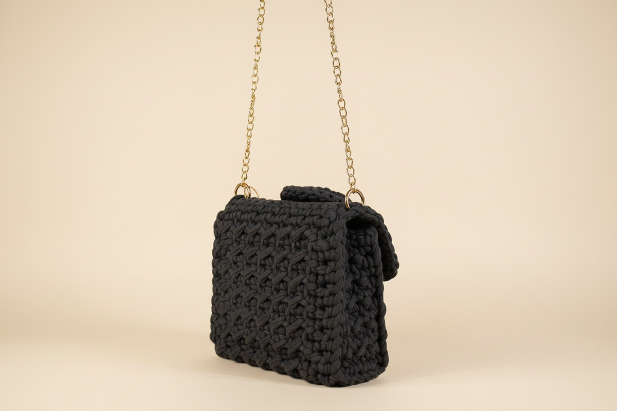 Side view of charcoal black woven shoulder bag