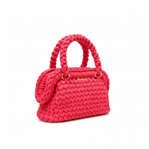 Bright pink handwoven handbag with braided handles and gold-tone hardware, right three-quarter view