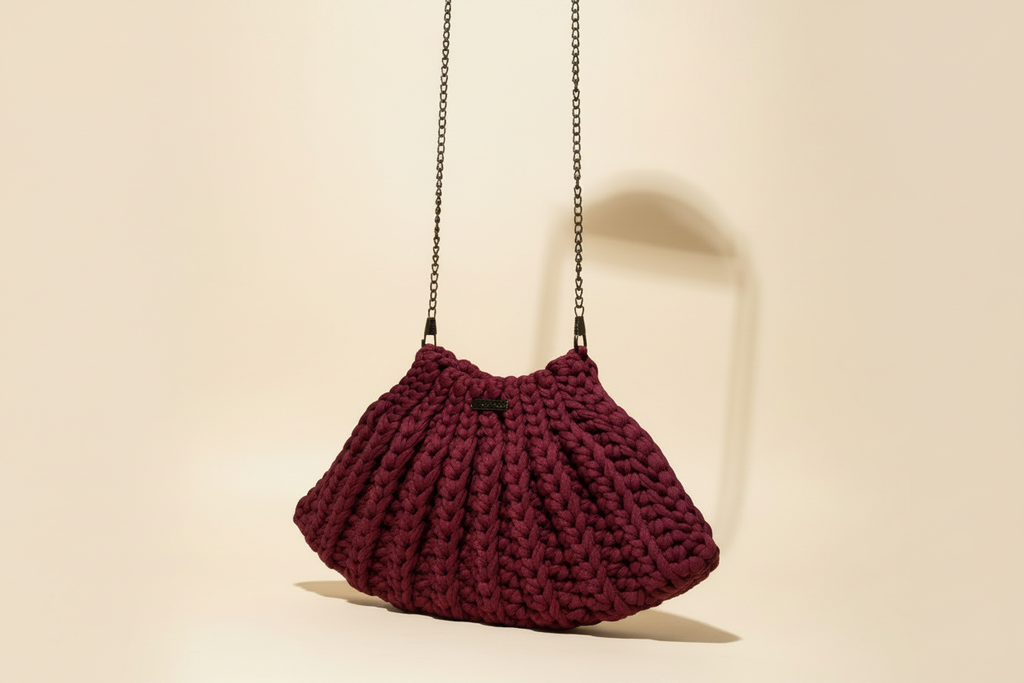 Alternate angle of a burgundy crocheted shoulder bag with a long chain strap